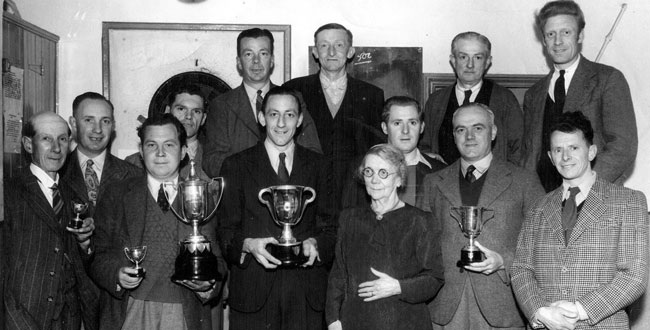 Fanny Brutnell presents trophies to the Kibworth Angling Society in the Royal Oak pub, around 1950.