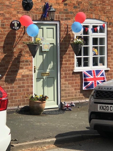 Houses decorated with balloons and Union Jack flags.