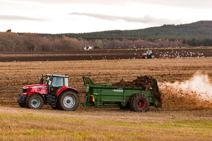 farmers spreading treated sewage sludge